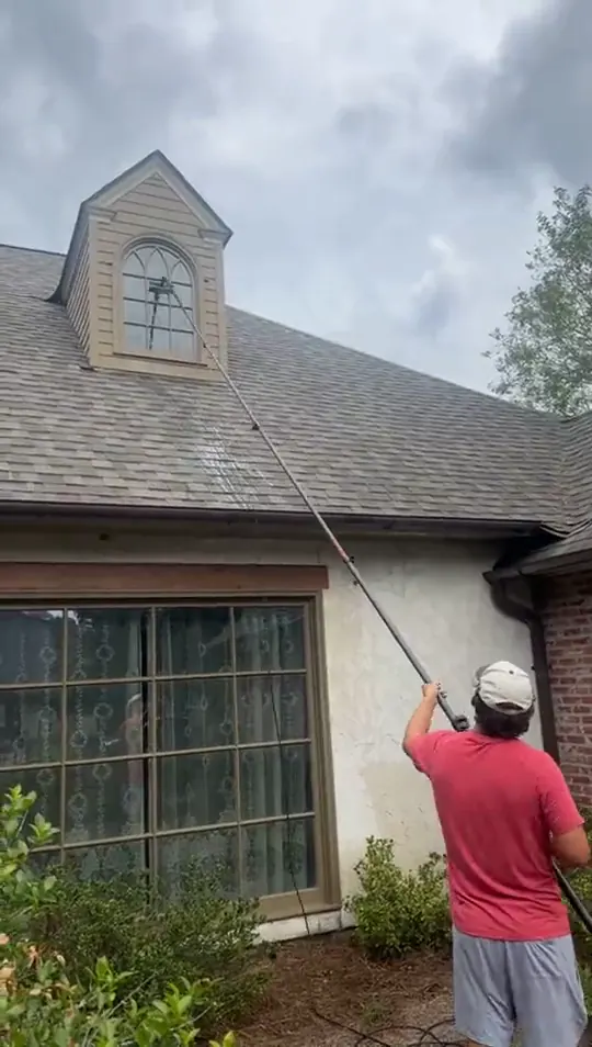 Water fed pole reaching a dormer window on a steep roof