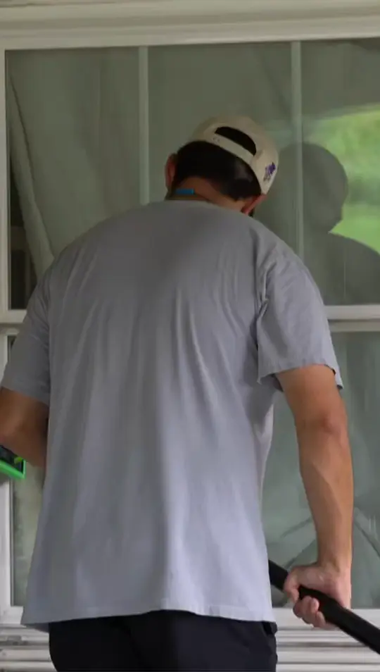 Boot Krewe technician detailing the lower sash of a window with a hand tool