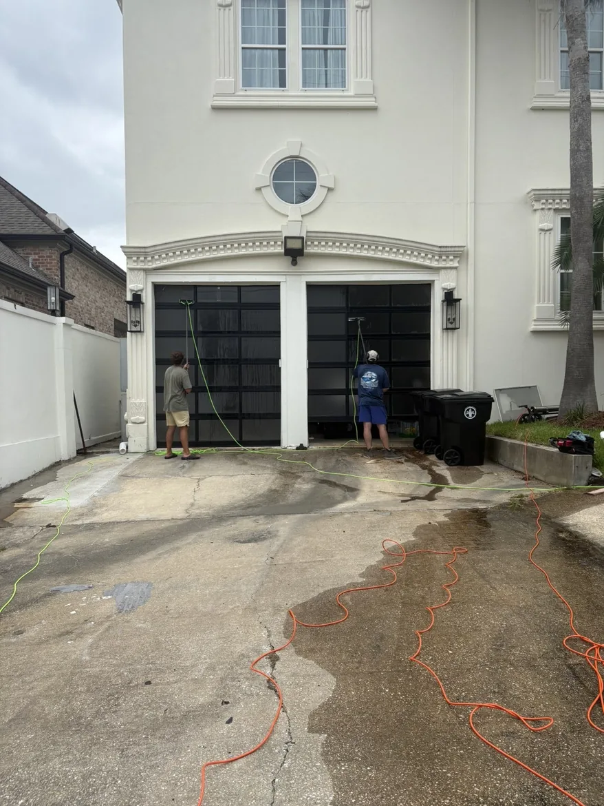 Boot Krewe crew washing a driveway with water running across the concrete